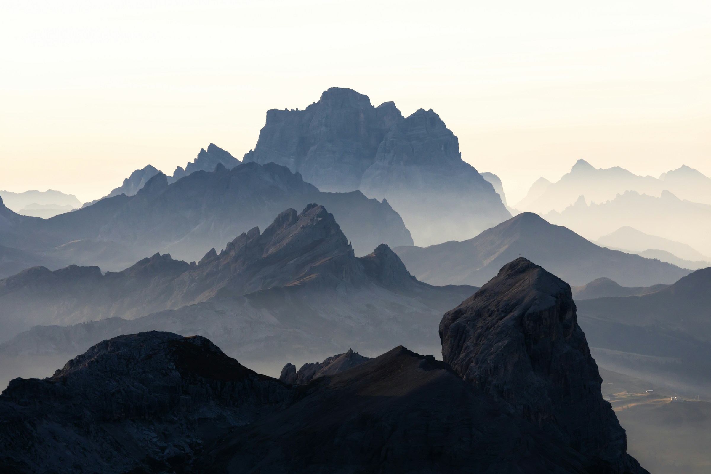 Layered mountain ridges fading into a white sky