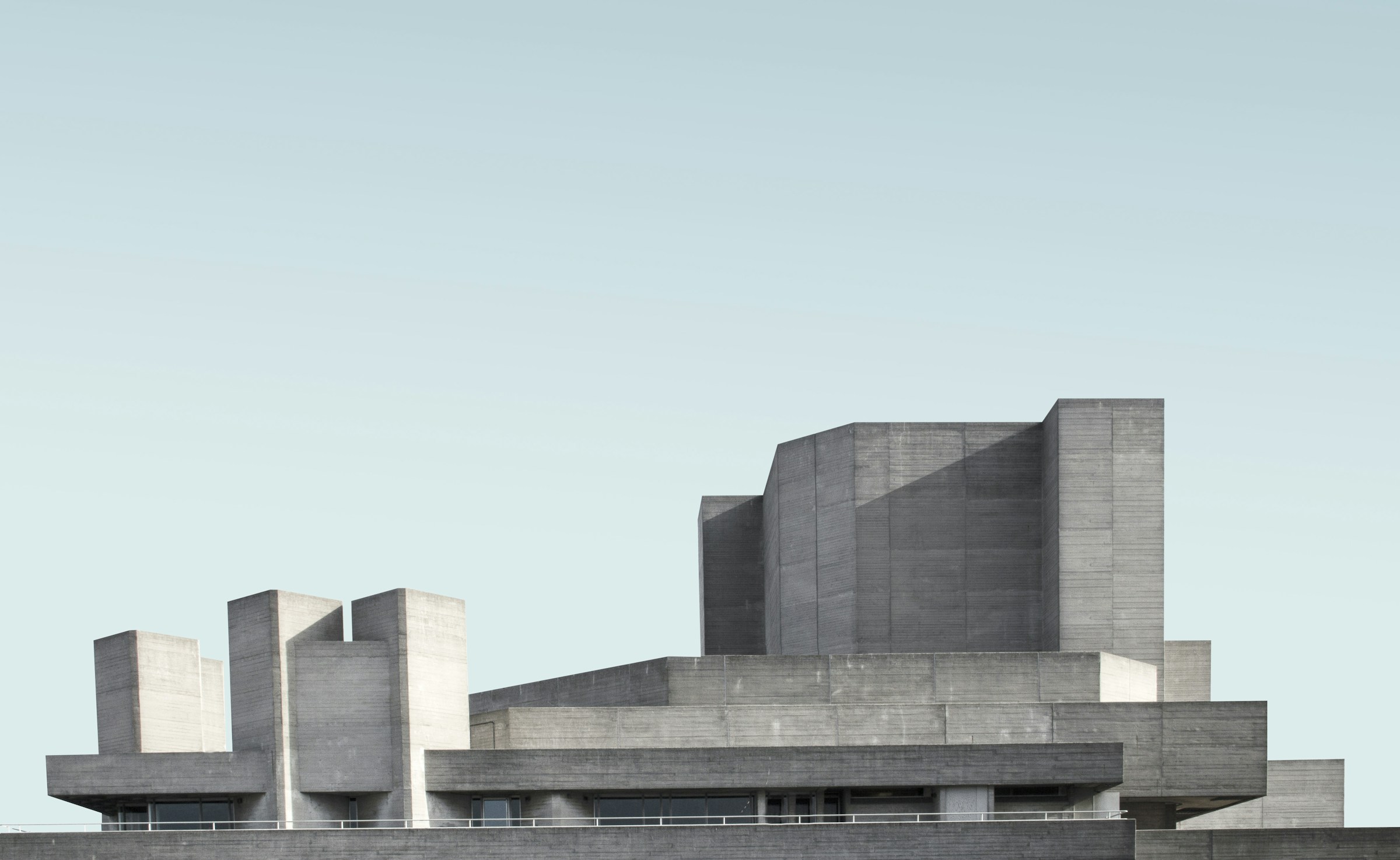 A pale concrete modernist building against an open sky
