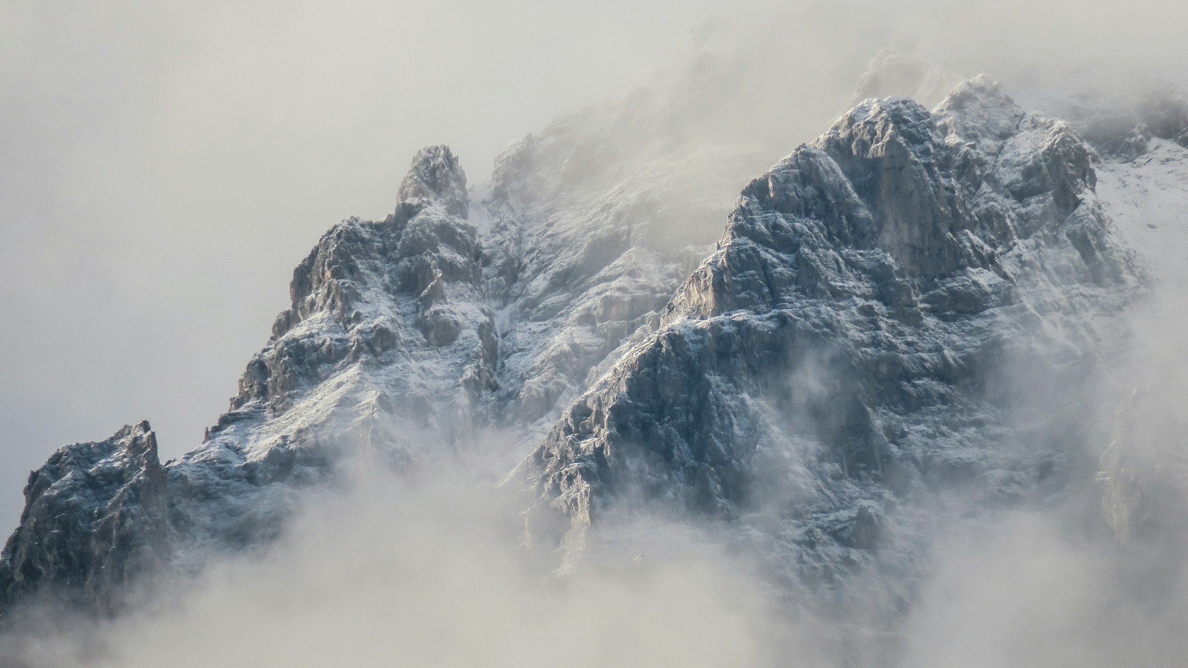 A mountain ridge shrouded in low fog